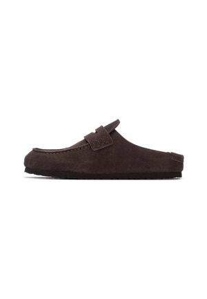 Zapato marrón de ante sin cordones con punta redondeada, tira decorativa y superficie texturizada. Cuenta con suela de goma plana para mayor comodidad.