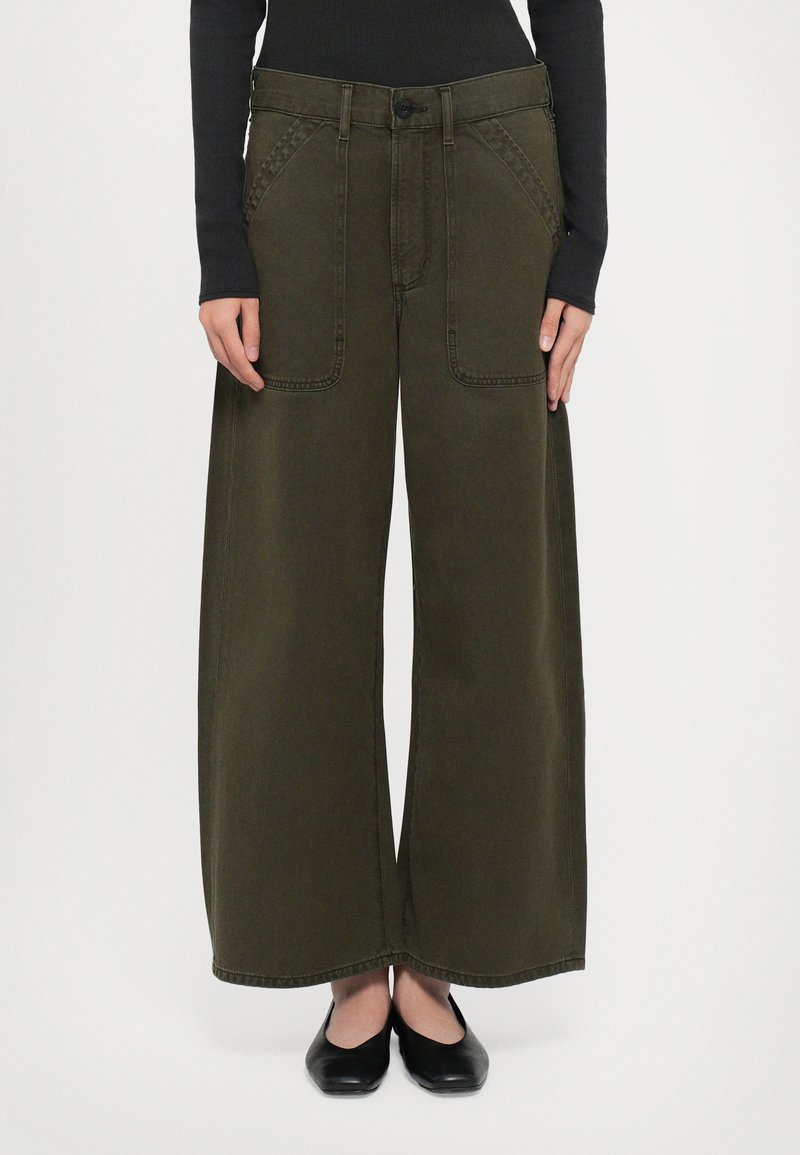 Brede olivegroene broek gemaakt van stevig materiaal, met voorzakken, een knoopsluiting en ton-sur-ton stiksels bij de naden.