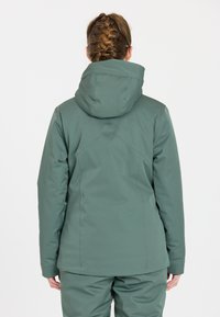 Grüne wasserdichte Jacke mit einem figurschmeichelnden Design, verstellbarer Kapuze und glatter Textur. Mit Nahtdetails für zusätzliche Struktur.