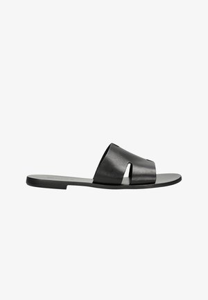 Schwarze Leder-Slides mit einem breiten Riemen mit Ausschnittdesign, flacher Sohle und glatter Textur, geeignet für die Freizeit.