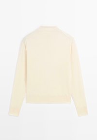 Pull en laine de pêche clair à manches longues avec un col montant, des poignets et un ourlet côtelés. Texture douce avec un design minimaliste, épaules sans coutures.