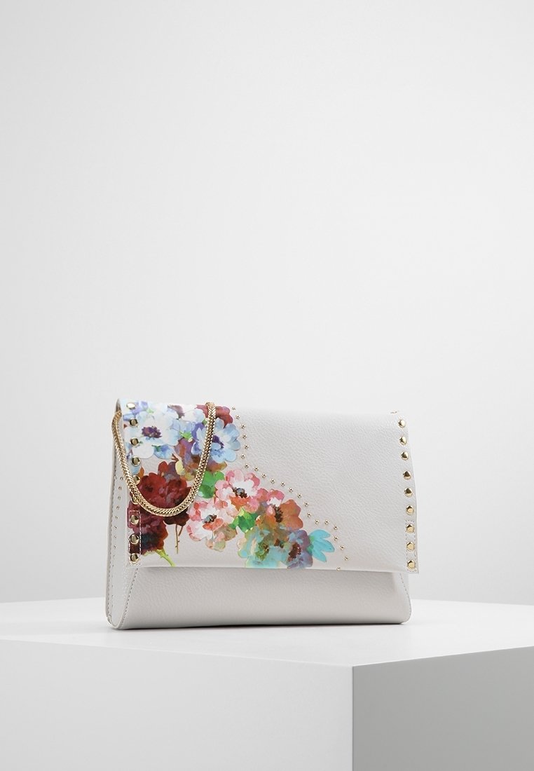 Väskan är i vitt läder med blommönster i rosa, blått och rött. Den har en guld kedja som axelrem och guldfärgade nitar längs sidan.