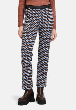 Pantaloni elasticizzati a motivi in nero, marrone, blu e forme di diamante azzurro chiaro. Presentano una ampia vita elasticizzata nera. Si fermano all'altezza della caviglia.