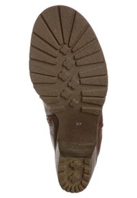 Suela de goma marrón con patrón texturizado y ranuras, tamaño marcado 37, diseño robusto para tracción y durabilidad.