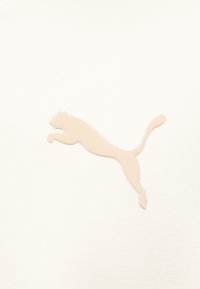 Σιλουέτα πούμα που πηδάει, σε μπεζ χρώμα, σε λευκό υφασμάτινο φόντο με υφή.