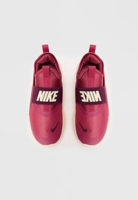 Pari maroon Nike slip-on kengät, joissa on musta swoosh-logo varpaissa ja leveät mustat joustohihat, joissa on valkoinen Nike-teksti.