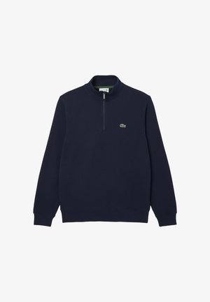 Sweatshirt bleu marine avec une fermeture éclair quart, doté de manches longues et d'un petit logo vert Lacoste sur la poitrine gauche. Texture douce et couleur unie.