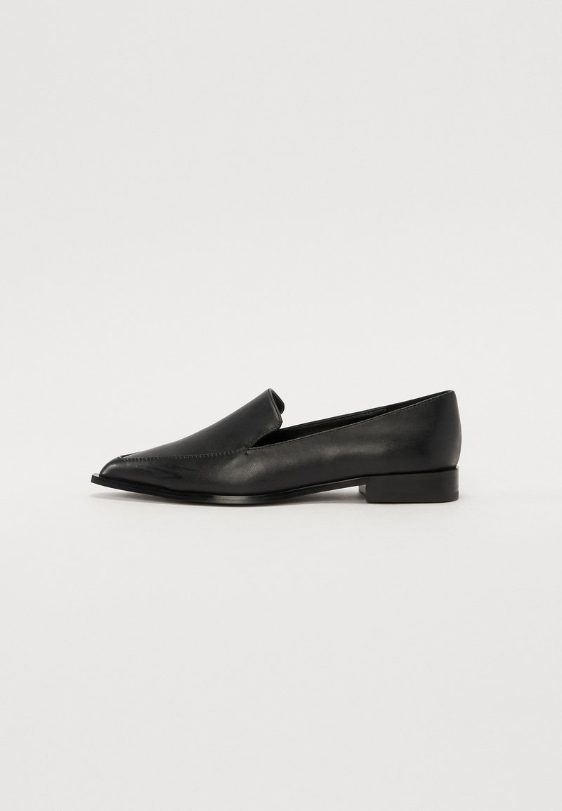 Mocasines de cuero negro con punta afilada, textura suave, detalles de costura mínimos y un tacón rectangular bajo.
