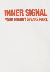 Texte rouge sur fond blanc affichant "INNER SIGNAL YOUR ENERGY SPEAKS FIRST" en lettres majuscules et en gras.