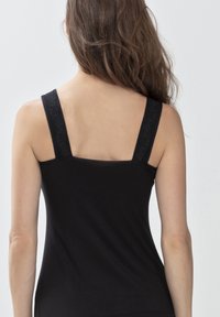 Canottiera nera con spalline larghe, caratterizzata da una texture liscia. Le spalline presentano un accento in pizzo. Vista da dietro, mostra dettagli sulle spalle e sulla schiena.