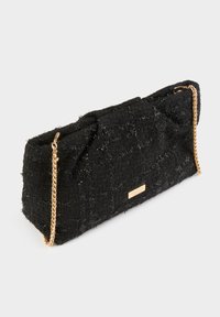 Clutch bag nera con texture, dalla forma strutturata, caratterizzata da una tracolla a catena e un piccolo logo metallico.