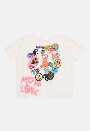 Kremowy bawełniany t-shirt z kolorowym zestawem naszywek haftowanych oraz nadrukowanych grafik, z napisem "MORE LOVE" w różowym stylu malowania sprayem.