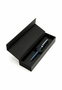 Sininen metallikynä kirkkailla hopeisilla yksityiskohdilla, lepäämässä mustassa suorakulmaisessa laatikossa, sidottuna mustalla nauhalla. Avoin laatikko paljastaa sisätilan tekstuurin.