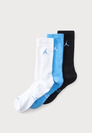 Tri páry rebrovaných ponožiek typu crew v bielej, svetlo modrej a čiernej farbe s modrým logom Jumpman blízko horného stredu každej ponožky.