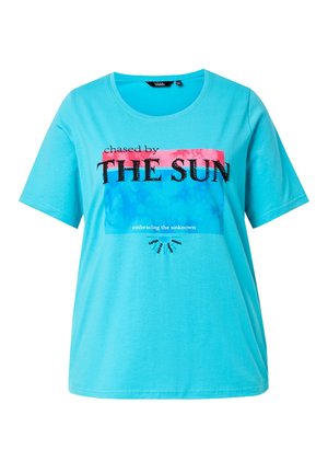 Helles blaues T-Shirt mit kurzen Ärmeln, bedruckt mit dem Text "chased by THE SUN", pink-blauem rechteckigem Hintergrund und einer kleinen, perlenbesetzten Sonnenstrahl-Dekoration.