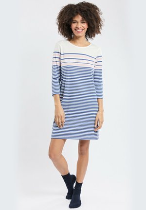 Robe rayée avec un haut blanc orné de bandes horizontales bleu marine et rose, manches trois-quarts et coupe décontractée. Portée avec des chaussettes bleu marine.