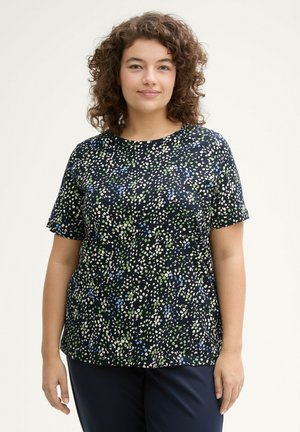 T-shirt bleu marine à manches courtes avec un motif texturé de points blancs, verts et bleus, doté d'un col rond et d'une coupe décontractée.