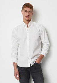 Witte button-up shirt met een klassieke kraag, lange mouwen en een subtiele logodetail op de borst. Glad materiaal en slank fit.