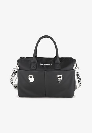 Czarna nylonowa torebka z dwoma górnymi uchwytami, odpinanym paskiem, dwiema przednimi kieszeniami i srebrną metalową galanterią. Ozdobiona przypinkami z kreskówkowymi postaciami psa i mężczyzny.