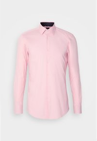 Chemise rose clair à manches longues avec boutonnière sur le devant et col pointu, présentée sur un fond clair uni.