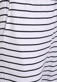 Tela blanca con estrechas rayas verticales negras; la textura presenta acanalados verticales; no se observan patrones ni detalles adicionales.