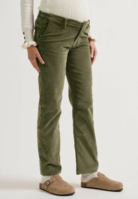 Olivgrüne Cordhosen mit schmaler Passform, ausgestattet mit einem Reißverschluss und Knopfverschluss, seitlichen Taschen und dezenten Steppdetails.