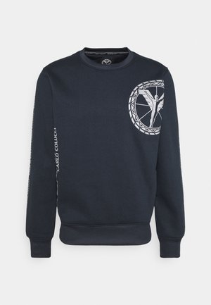 Felpa blu marina realizzata in misto cotone; presenta una grafica circolare bianca con una figura sul davanti e testo lungo le maniche. Collo a giro classico.