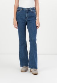 Uppsvängda blå denimjeans med hög midja, med framfickor, diskret sömnad och fransade detaljer i fållen. Avslappnad passform med rak ben. 