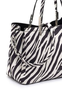 Sac à main à motif zèbre avec deux poignées, détails de fermoir en argent et fixation de la sangle latérale, vue en gros plan du coin supérieur.