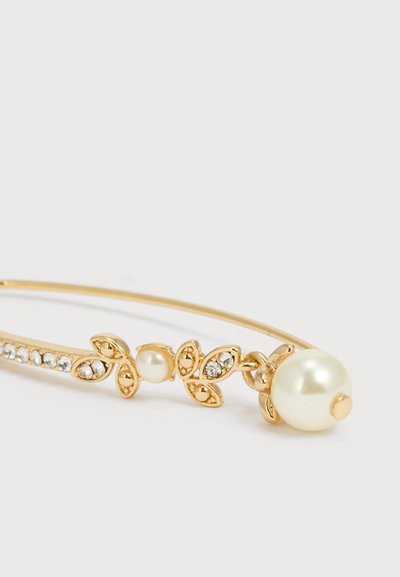 Χρυσό βραχιόλι με λεπτομέρειες σε σχήμα φύλλου, μικρά κρύσταλλα, μια μεσαία πέρλα στο κέντρο και ένα μεγαλύτερο κρεμαστό κολιέ με πέρλα.