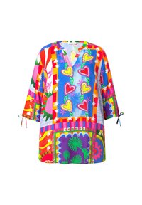 Blouse tunique colorée avec un col en V, des manches trois-quarts avec des liens, et des motifs audacieux de cœurs, d'étoiles et de formes abstraites dans diverses couleurs.