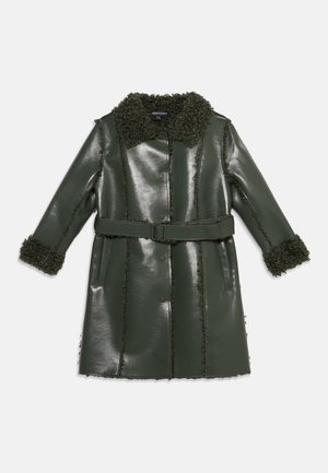 Long manteau vert foncé en similicuir avec ceinture, fermeture par boutons, col et poignets en shearling texturé sur fond uni.