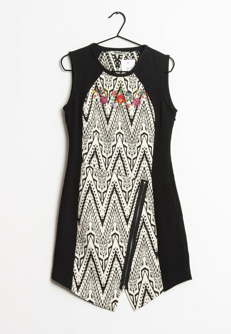 Robe sans manches noire et blanche avec un corps à motif géométrique, une broderie florale décorative au niveau du col et un détail de fermeture éclair à l'avant.