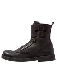 Bottine en cuir noir à bout rond, avec un laçage sur le devant, deux boucles réglables, surface texturée et semelle en caoutchouc plate.