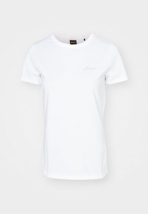 Camiseta blanca de manga corta hecha de algodón. Presenta un escote redondo y un sutil logo bordado en el pecho. Textura suave.