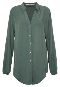 Blouse verte à manches longues avec une finition texturée, fermeture boutonnée à l'avant et coupe décontractée. Comprend un col classique et un ourlet arrondi.