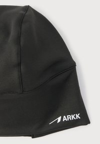 Μαύρο, εφαρμοστό υφασμάτινο καπέλο με ορατές ραφές και λευκό λογότυπο "ARKK" με βέλος στην κάτω άκρη, σε λευκό φόντο.