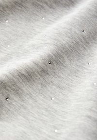 Tessuto grigio chiaro con una texture liscia, caratterizzato da piccole paillettes brillanti disperse su tutta la superficie.