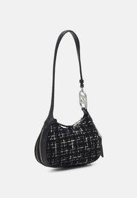Sac à main en tweed noir et blanc avec une forme incurvée, des accents en cuir, une fermeture éclair en argent et une bandoulière amovible avec un charme en forme de logo.