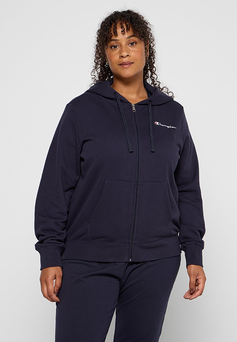 Felpa con zip di colore navy, realizzata in tessuto morbido, con tasca frontale, cordini e un piccolo logo sul petto. Texture liscia e vestibilità comoda.