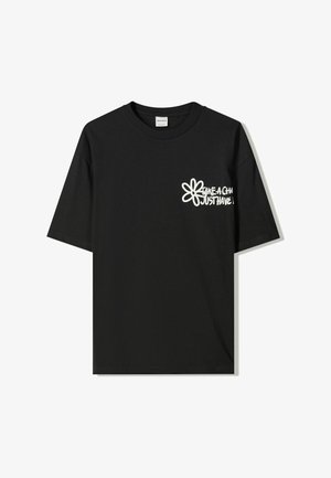 T-shirt in cotone nero con maniche corte, caratterizzato da un design grafico bianco con il testo “Take a Chill Just Have Fun” e un motivo floreale.