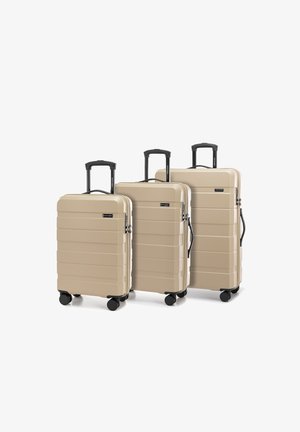 Tres maletas rígidas en color beige, con un diseño estriado, asas retráctiles negras y cuatro ruedas negras para mayor movilidad.