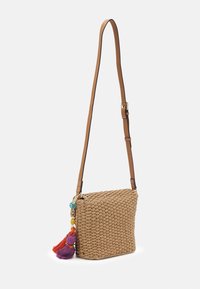 Borsa a tracolla intrecciata in paglia con cinturino in pelle marrone chiaro, caratterizzata da un accento di nappine colorate con perline arancioni, viola e blu.