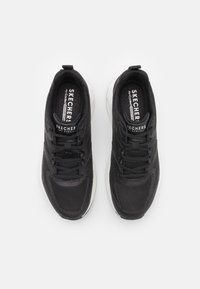 Sneakers neri in rete con una finitura texturizzata, dotati di una suola ammortizzata e di un design con lacci. Brand visibile sulla soletta e sulla linguetta.