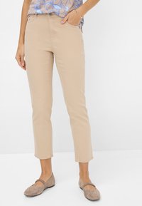 Beige katoenen blend cropped broeken met een rechte pijp, voorzakken en een knoopsluiting. Gecombineerd met lichtbruine flats.