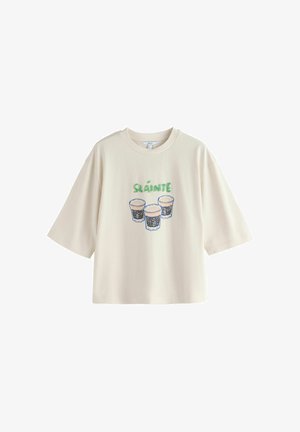 Väriltään luonnonvalkoinen lyhythihainen T-paita, jossa on edessä "SLÁINTE"-teksti ja kolme täytettyä tuopillista kuvituksena.