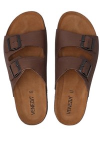 Brown leather slide sandals featuring two adjustable straps with metal buckles, soft footbed, and a textured sole. Brand name visible on the insole.