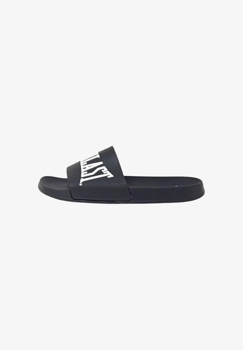 Sandalo nero con suola piatta e cinturino largo. Presenta un logo in rilievo bianco. Realizzato in materiale sintetico per un uso casual.