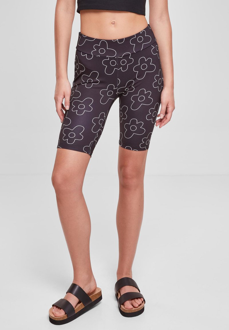Fekete virágmintás bicikshorts, elasztikus anyagból készült, magas derékkal és sima textúrával, barna klumpásokkal párosítva.