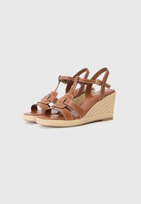 Brown leather wedge sandals with multiple straps and a woven jute platform. Features an open toe and adjustable ankle strap with a buckle.